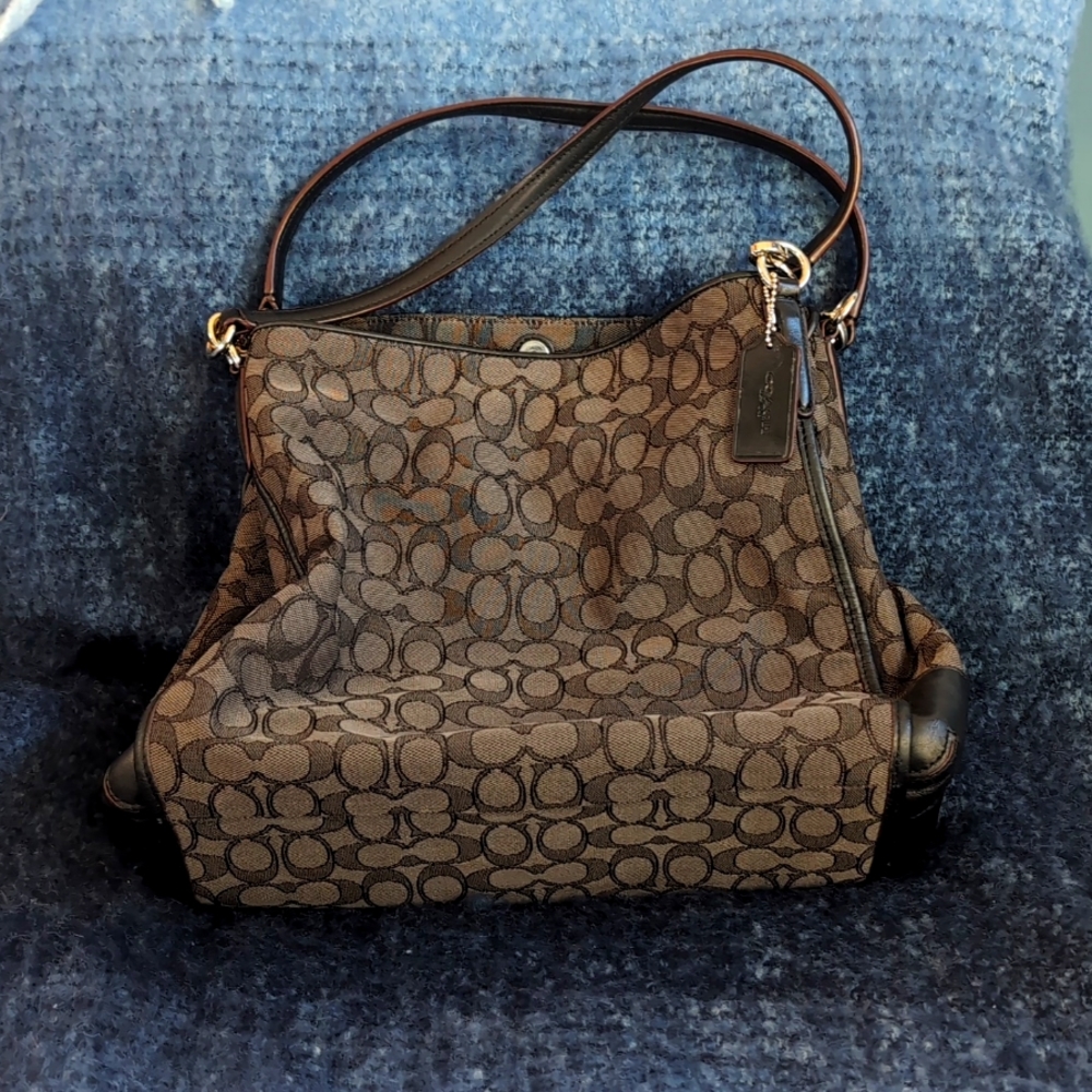 Coach black purse with three compartments, zipper and magnetic closures.